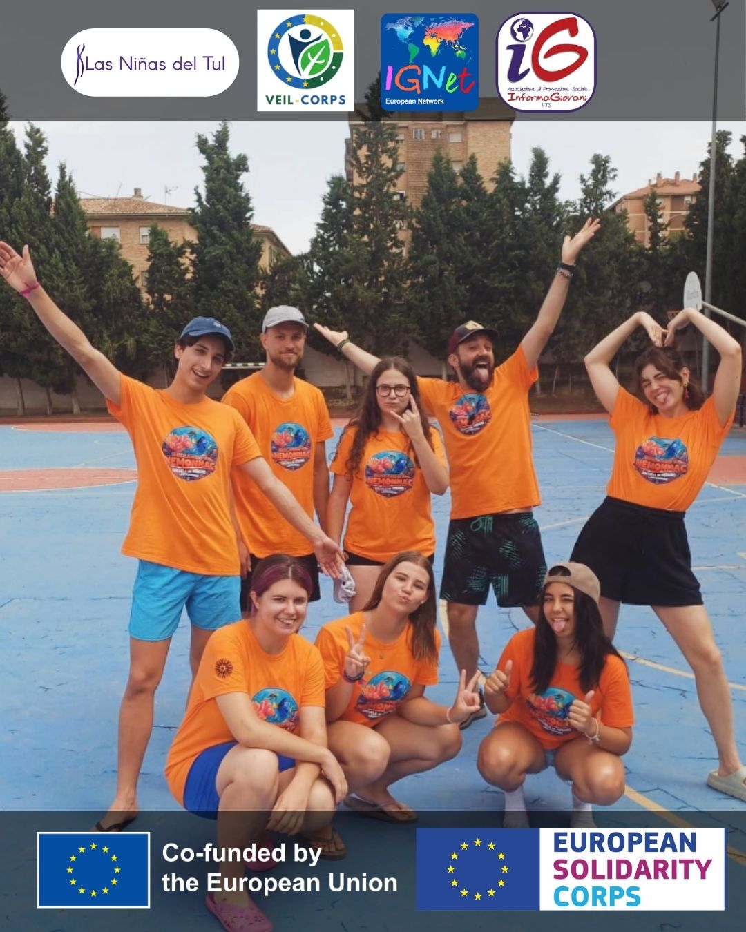 gruppo di giovani con indosso magliette arancioni in posa