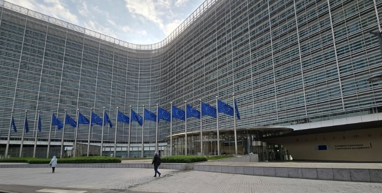 Il palazzo Berlaymont, sede della Commissione Europea a Bruxelles, con la fila di bandiere dell'Unione Europea davanti all'ingresso.