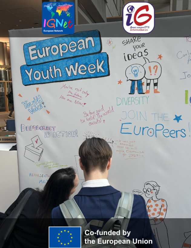 Partecipanti scrivono idee e messaggi sul murale collettivo della European Youth Week a Bruxelles, tra disegni e slogan su democrazia, diversità e partecipazione giovanile.