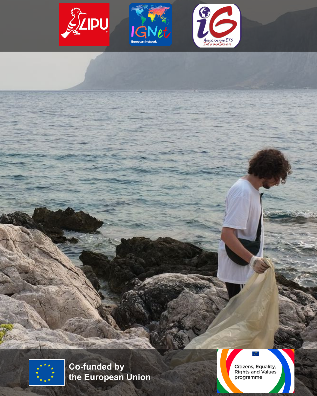 ragazzo in piedi su degli scogli con una busta della spazzatura in mano, di sfondo il mare e isola delle femmine