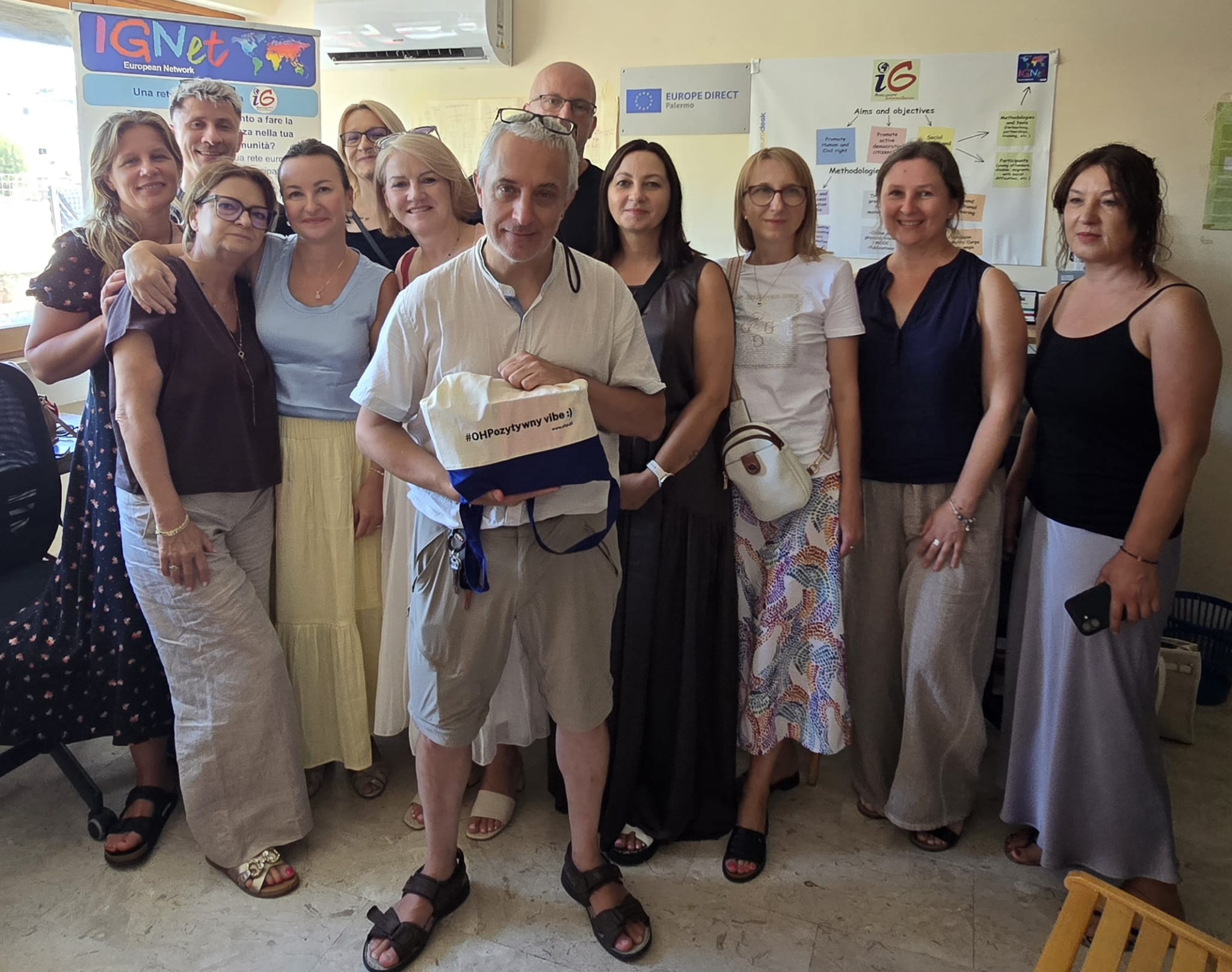 gruppo di persone in piedi ad un incontro rivolti verso l'obiettivo della fotocamera