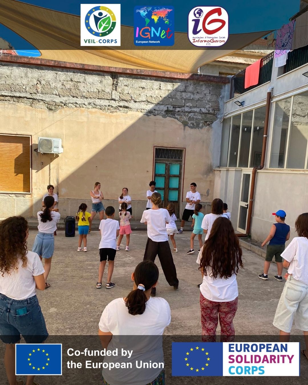 gruppo di bambini e bambine che ballano insieme a persone adulte